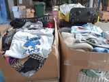 two boxes with clothes and luggage on them in a warehouse