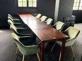 une longue table entourée de nombreuses chaises dans une pièce