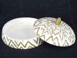 a white and gold box with a lid on a black background
