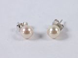 a pair of pearl earrings on a white surface