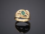 a gold ring with an emerald stone and diamonds