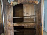 a wooden cabinet with a door open on a tiled floor