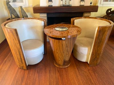 two chairs and a table in a room with a fire place