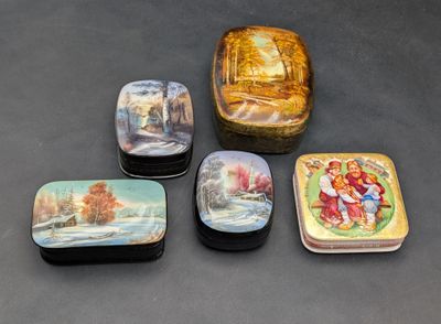 quatre petites boîtes ornées de motifs décoratifs, posées sur une table
