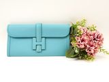 blue leather clutch bag with flowers on white background