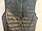 Dans une pièce, quelqu'un tient un gilet noir accroché à un cintre.