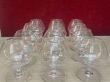 six empty wine glasses sitting on a table with a red background
