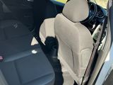 une petite voiture dont la portière est ouverte et le siège conducteur rabattu