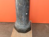 a statue of a man standing on top of a wooden block