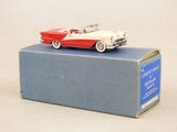 une petite voiture rouge et blanche posée sur une boîte