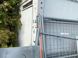 a metal gate with a sign on it next to a fence