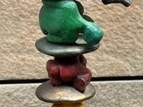 a statue of a man sitting on top of a stack of rocks