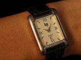 someone is wearing a watch on their wrist with a black band