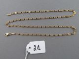 a close up of a gold chain with a price tag on it