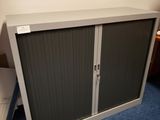 une armoire métallique à deux portes, avec un tiroir en dessous