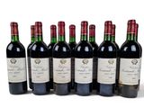 six bottles of red wine lined up in a row on a white surface