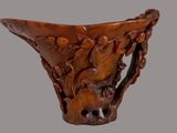 a close up of a wooden vase with carvings on it