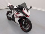 une photo d'une moto blanche et rouge garée dans un garage
