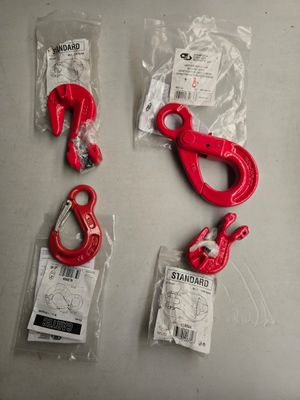 trois crochets rouges et une paire de crochets posés sur une table
