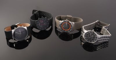 three different watches sitting on top of a black surface