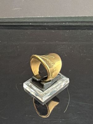 une bague en or posée sur un bloc de verre