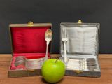 a green apple sitting next to a silver spoon and fork