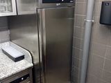 a stainless steel refrigerator in the corner of a kitchen