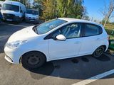 a small white car parked in a parking lot with a lawn mower attached to it
