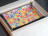 une boîte comportant un plateau orné d'un motif coloré
