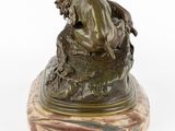 bronze statue of a woman sitting on a rock with a bird on her shoulder