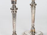 paire de bougeoirs en argent dont les socles sont ornés de motifs gravés