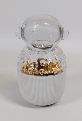 un petit bocal en verre orné d'un motif doré sur le couvercle