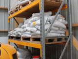 de nombreux sacs de ciment empilés sur les rayonnages de l'entrepôt