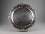 a silver plate with a decorative design on the rim