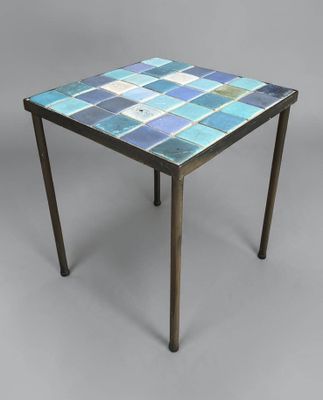 une petite table avec un plateau en carrelage bleu et des pieds en bois