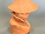 a clay sculpture of a woman with a hat on her head