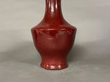a red vase that is sitting on a table