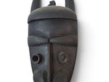 a black mask with horns on it on a wall