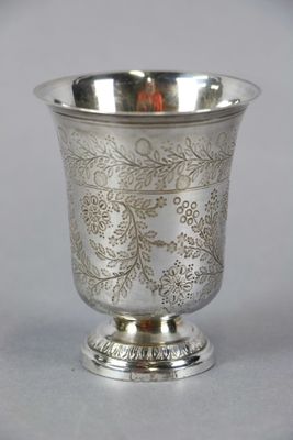 an antique silver cup with a floral design on the rim