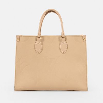 un sac à main beige posé sur une surface blanche