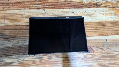 a black tablet computer sitting on a wooden table