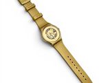 a close up of a gold watch on a white surface