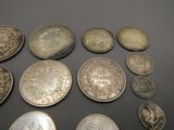 several different types of silver coins on a black surface