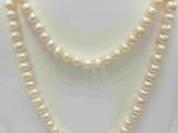 Le collier est composé de perles blanches et est présenté sur un mannequin blanc.