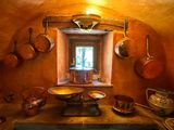 pots and pans are hanging on a wall in a kitchen