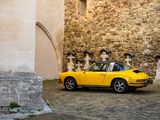 a yellow car that is parked in front of a building