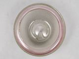 a glass with a pink rim sitting on a white surface