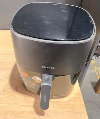 un mixeur noir et argent posé sur une table en bois