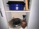 une casserole et une poêle bleues posées sur une étagère dans un placard