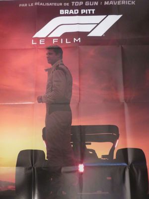 l'affiche du film « Le Film », sur laquelle figure un homme debout devant une voiture de course